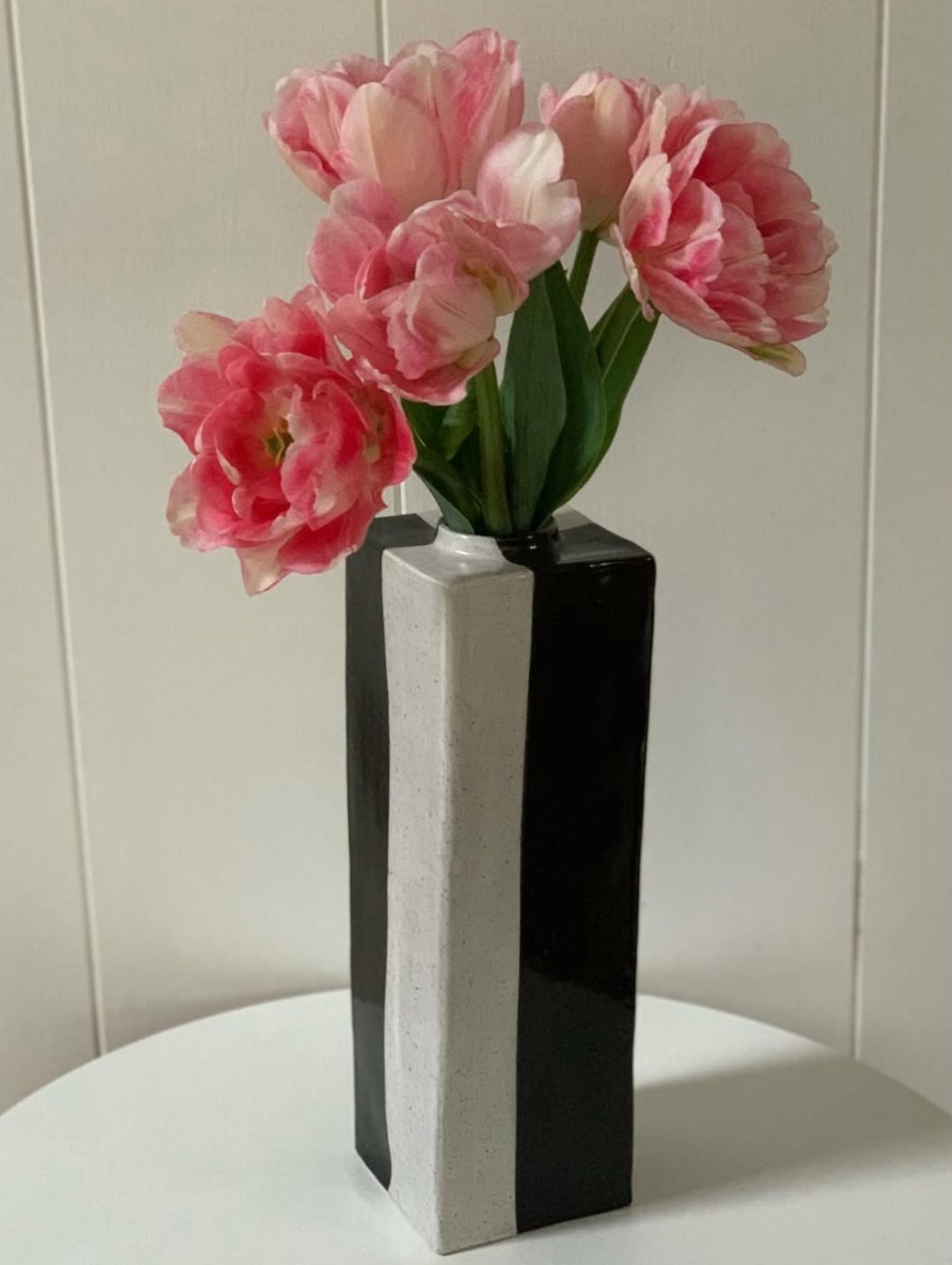 Black and white striped column vase with tulips